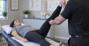 Chiropractor performing an orthopedic test to diagnose sciatica in Racine, WI